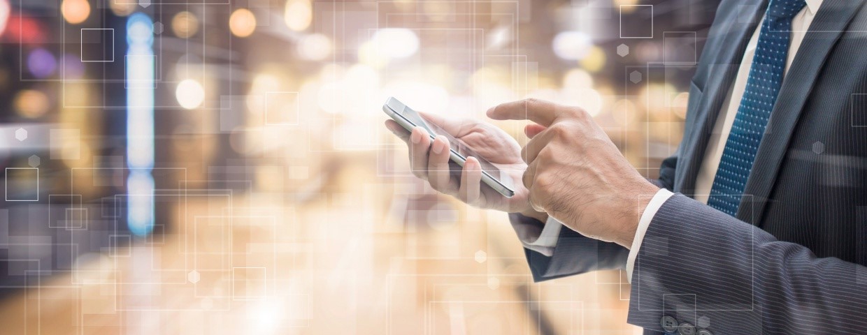 Businessman in a datacenter with a smartphone in his hands